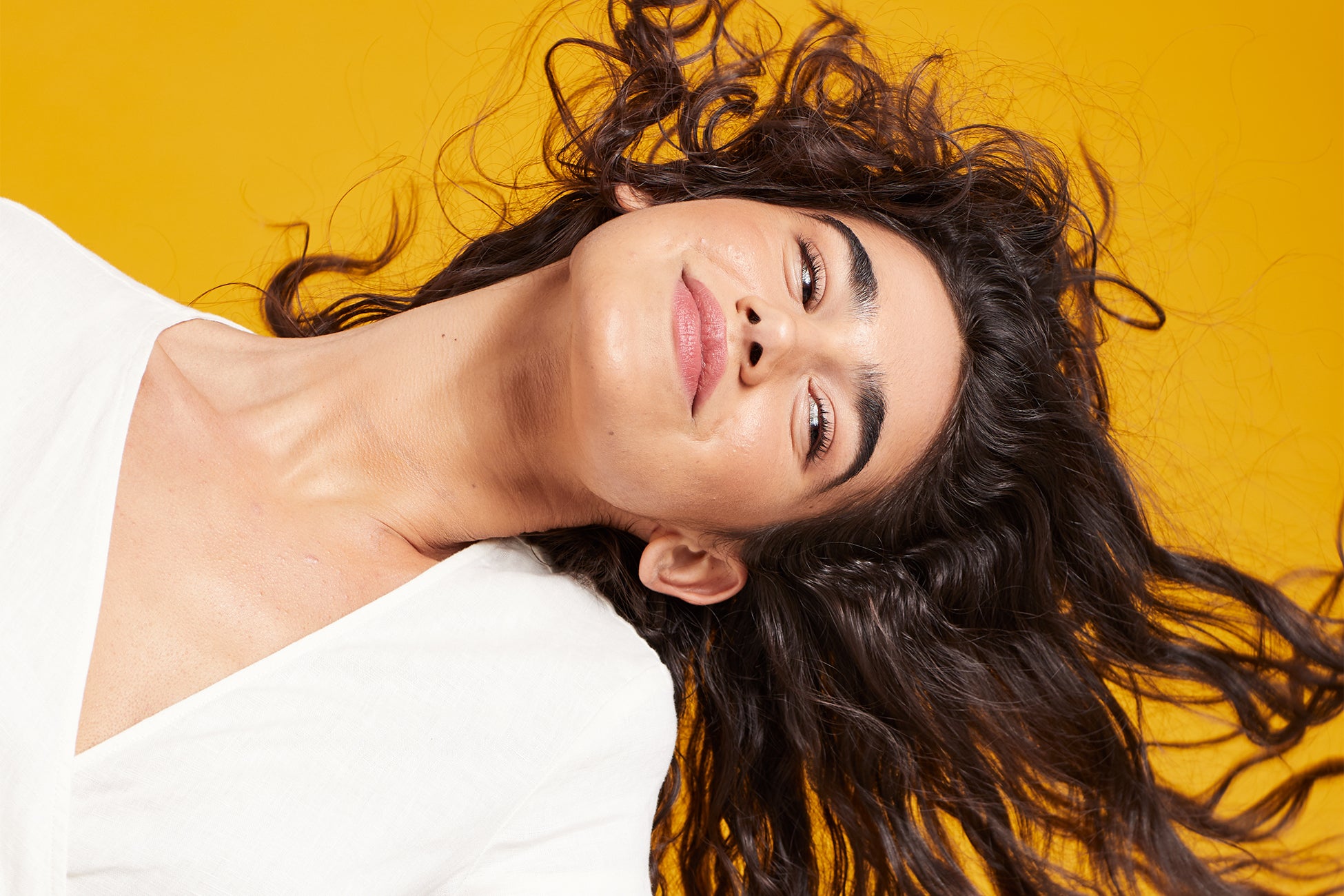 woman with brown hair laying on yellow floor